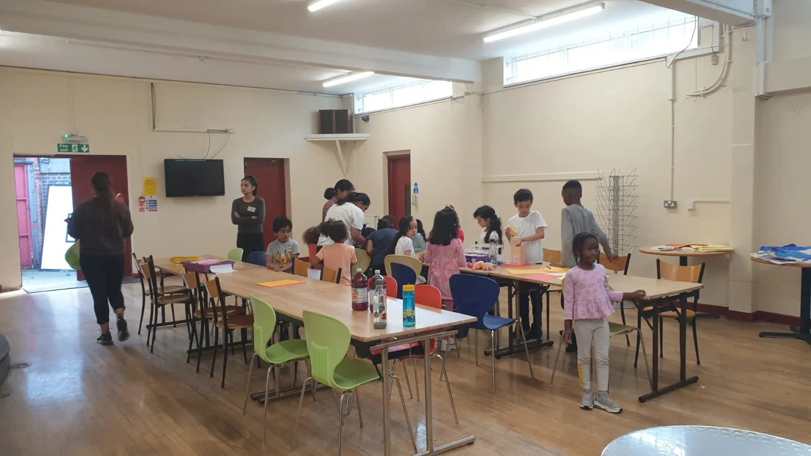 Children sitting at tables in the club’s activity room during after school club