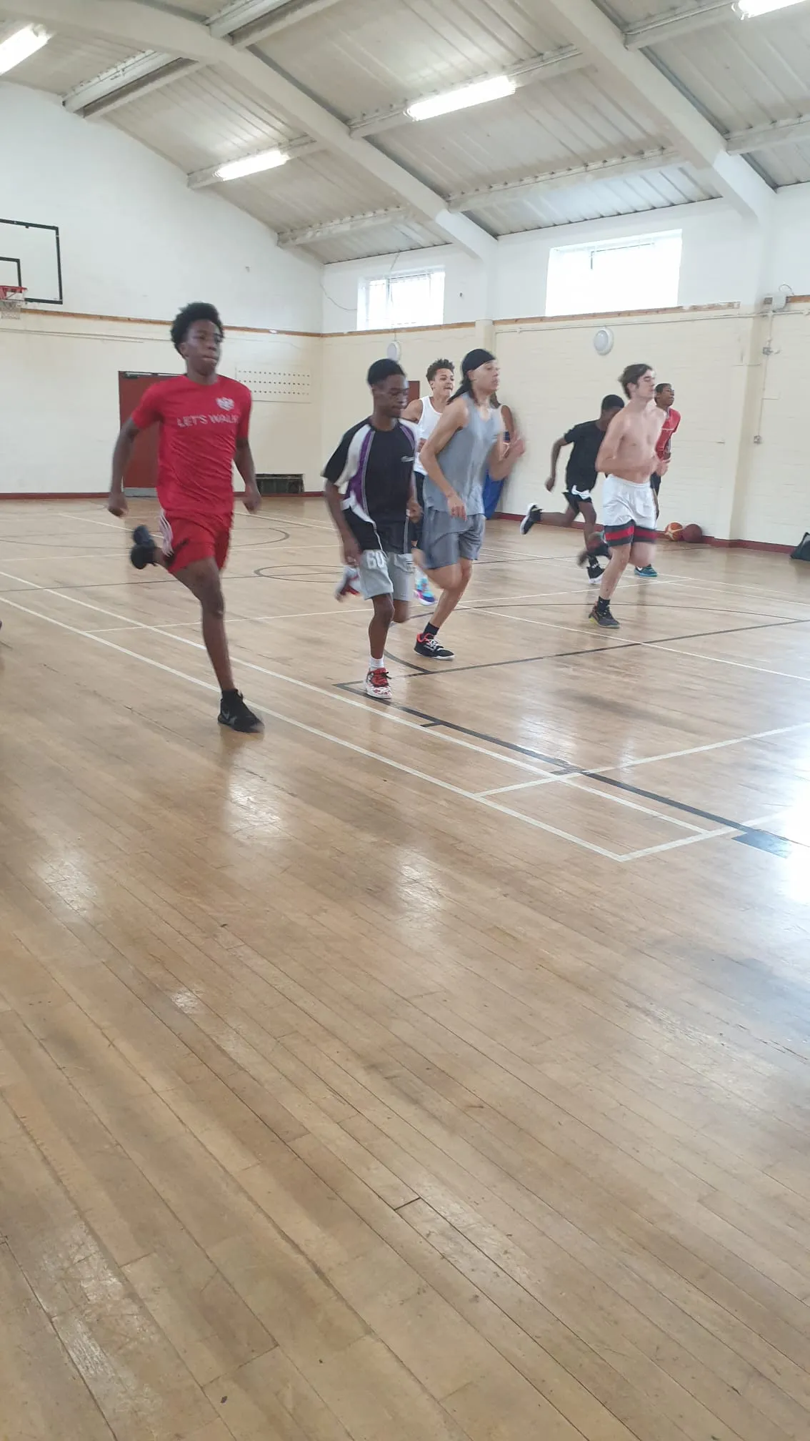 Teenagers running a training drill in the club’s sports hall